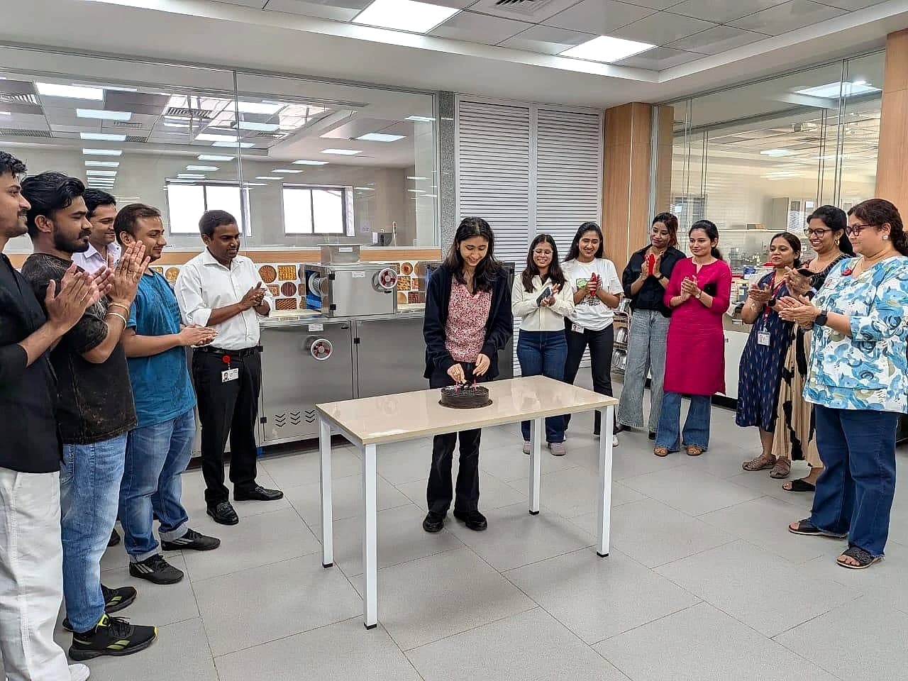 Keya cutting a cake with the Parle R&D team on her last day