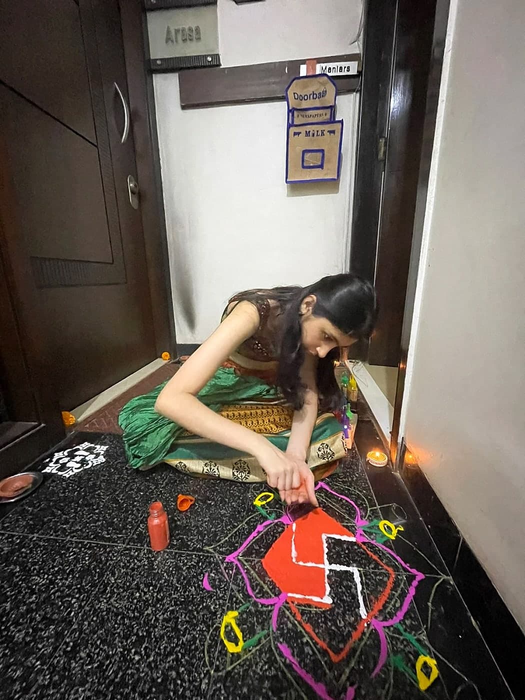 Keya making a rangoli at her doorstep