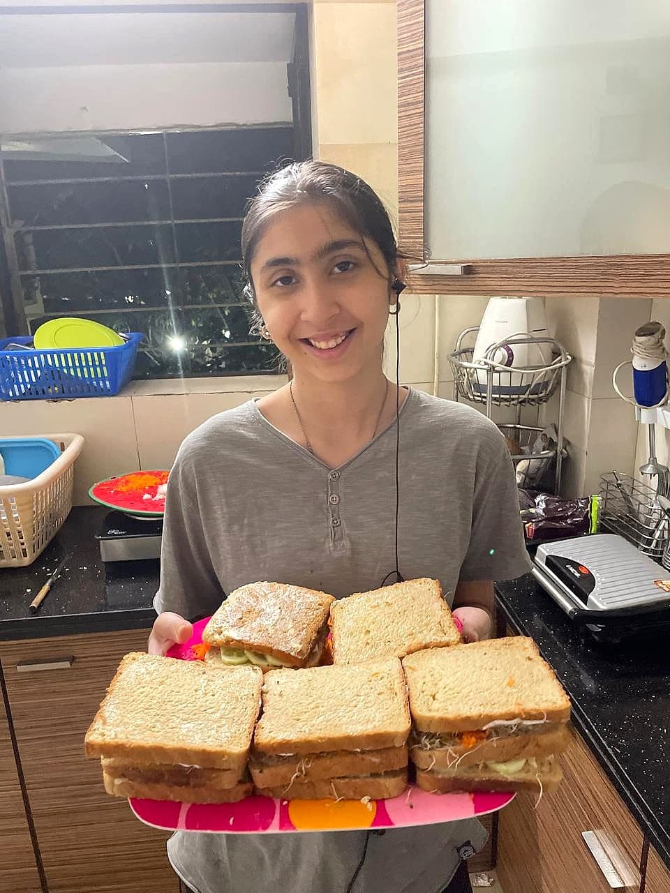 Keya holding a plate of sandwiches she made at home